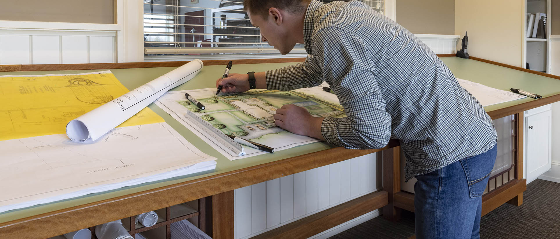 Christopher Alpay working on a construction design.